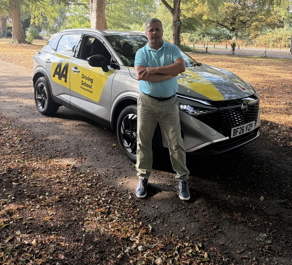 Maurizio, DVSA-approved driving instructor, standing beside his driving-school car